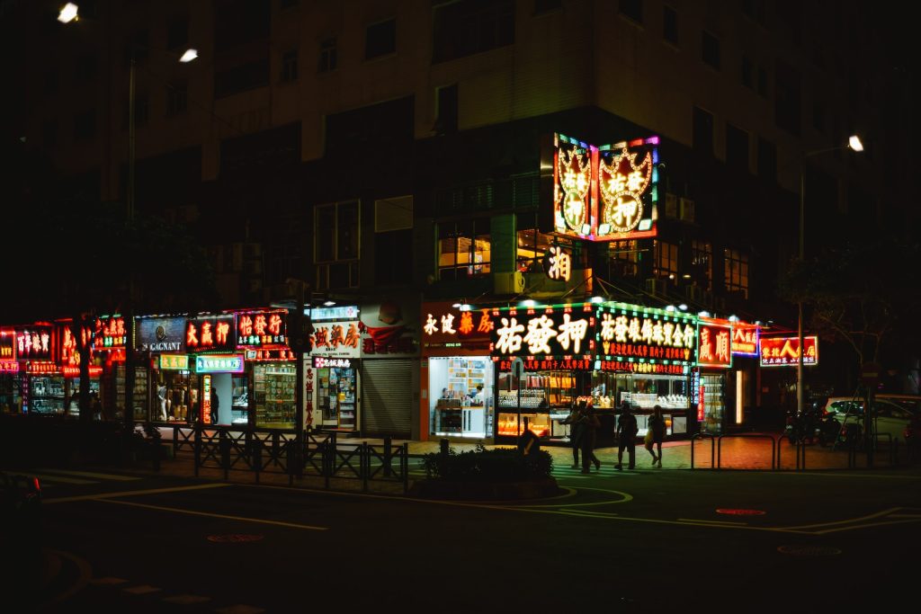 a street scene at night with a lit up food stand
