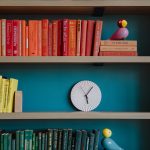 a bookshelf filled with books and a clock