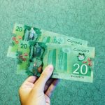 person holding two 20 Canadian dollar banknotes