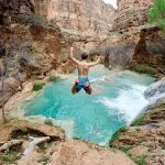 time lapse photography of man jumping on waterfalls