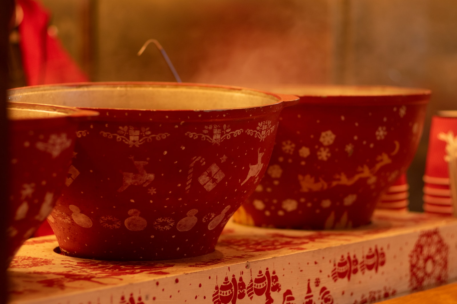 a row of red bowls sitting on top of a shelf
