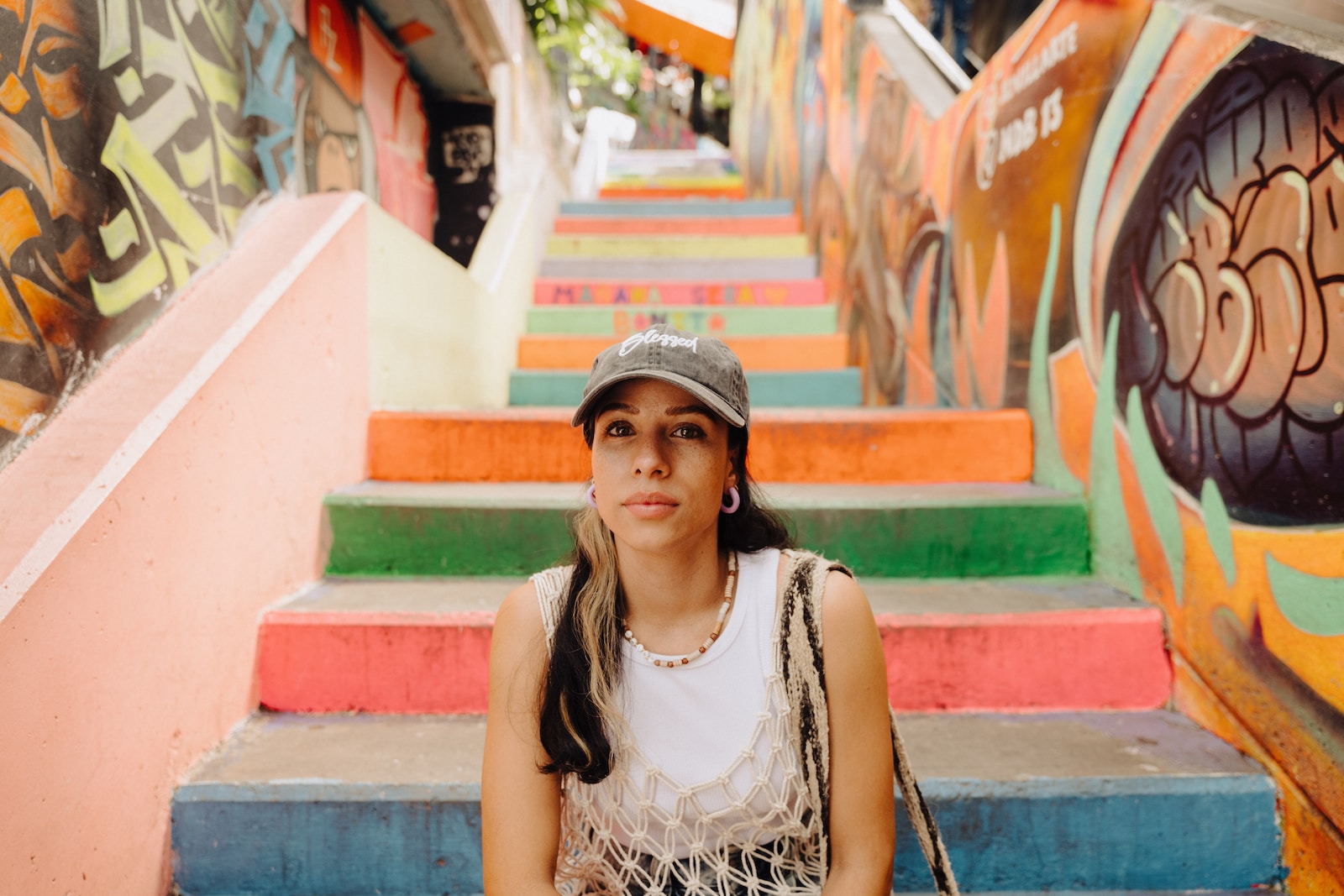 a woman sitting on the steps of a colorful staircase