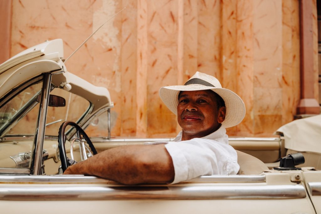 a man in a hat sitting in a car