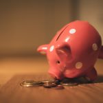 pink pig coin bank on brown wooden table