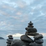 balanced stones on rock beside the ocean