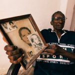 Portrait of Men with Photos in Frame