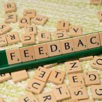 The word feedback is spelled out with scrabble tiles
