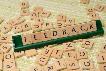 The word feedback is spelled out with scrabble tiles