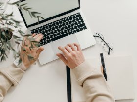 Person in Beige Long Sleeve Shirt Using Macbook Pro