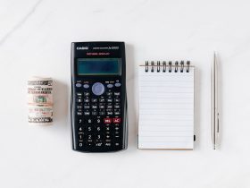Composition of calculator with paper money and notebook with pen