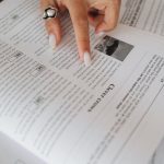 Close-Up View of a Person's Hand on a Book