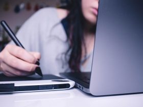 woman using drawing pad while sitting in front of laptop