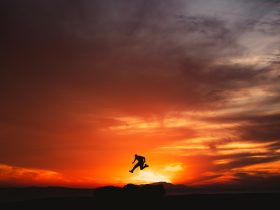a person jumping into the air at sunset