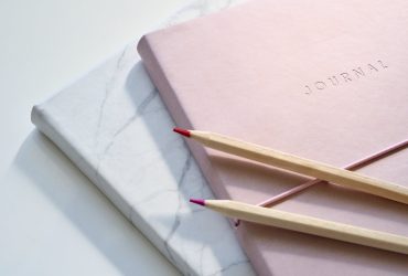 Closeup Photo of Journal Book and Pencils