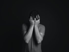 Gray scale Photo of Man Covering Face With His Hands