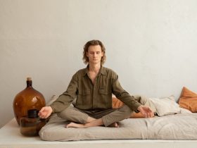 Serene man meditating in Lotus Pose on sofa